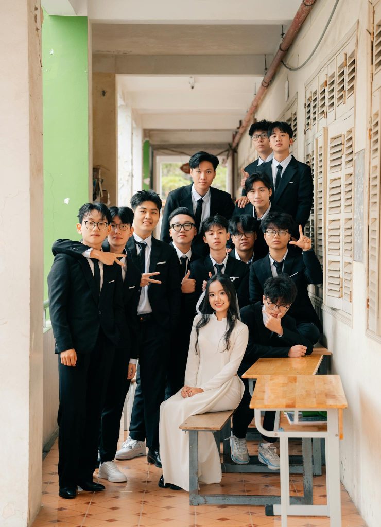 A group of students in formal attire posing in a school corridor in Hà Nội, Vietnam.