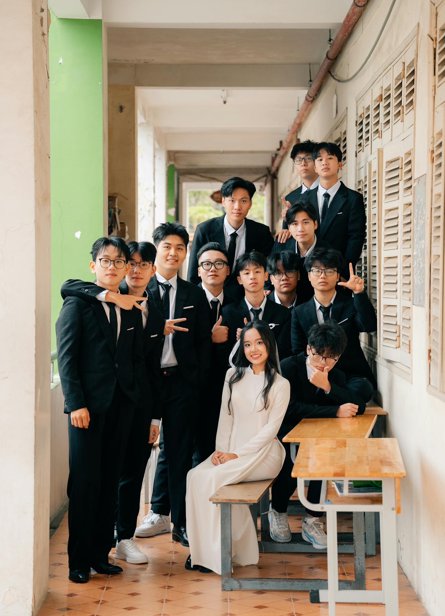 A group of students in formal attire posing in a school corridor in Hà Nội, Vietnam.