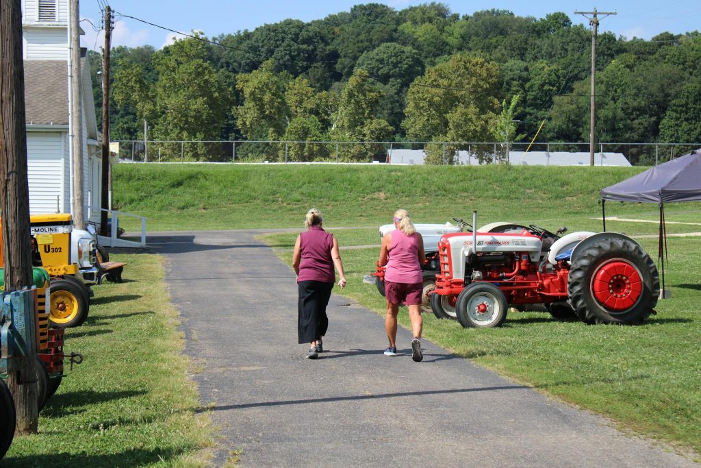 Two women walk past vintage tractors at a show in Lancaster, Ohio.