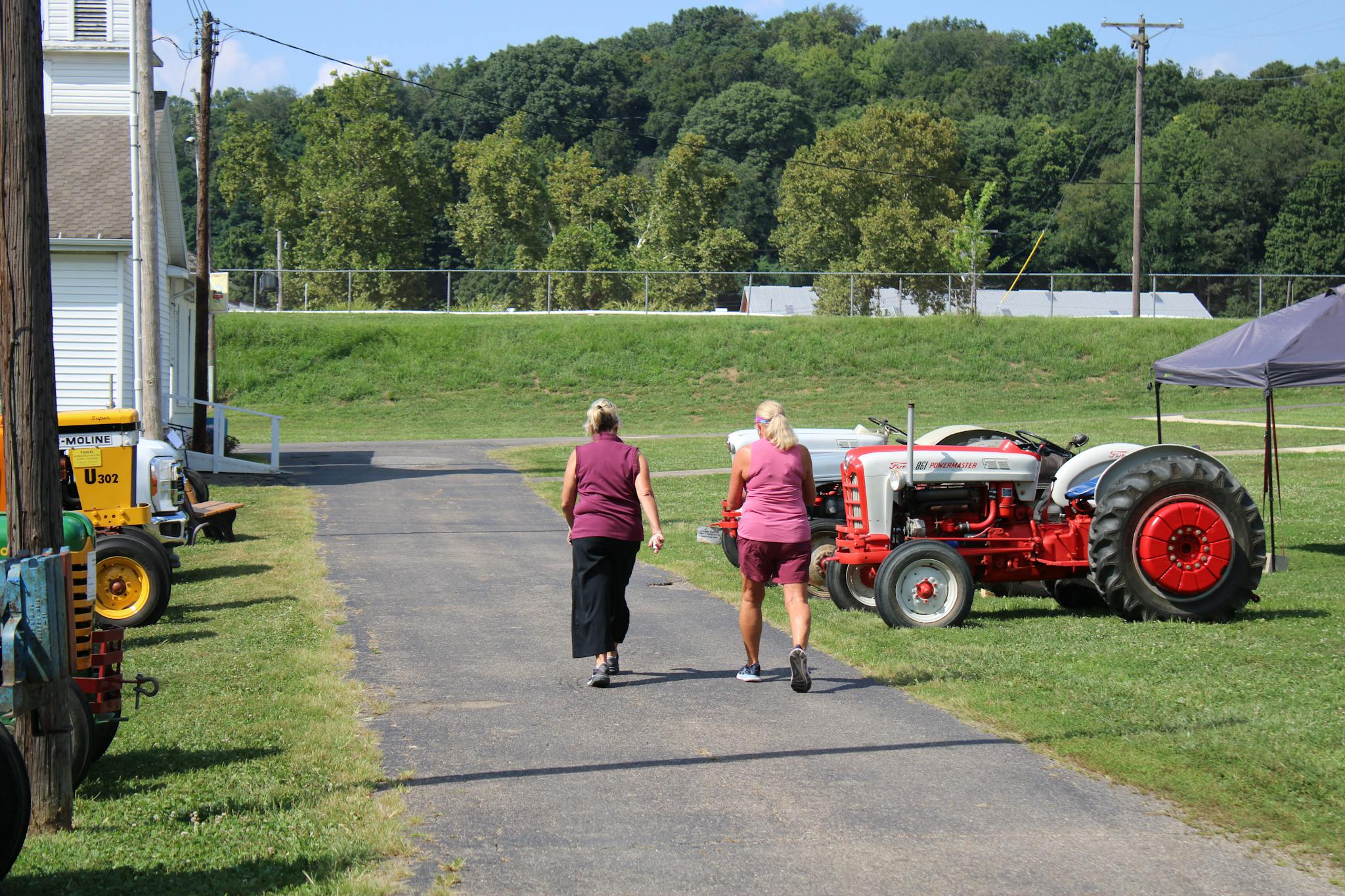 Two women walk past vintage tractors at a show in Lancaster, Ohio.